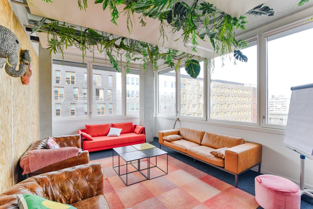 Espace détente moderne avec plantes et canapés colorés.