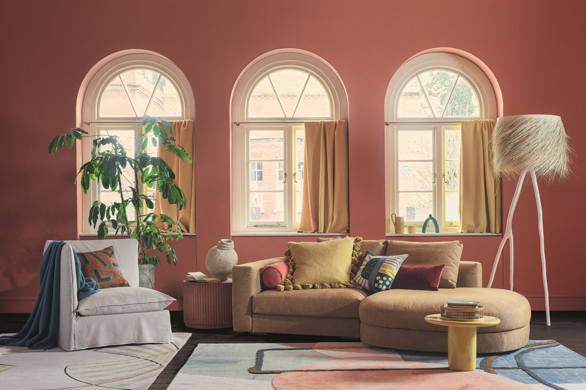 Salon moderne aux couleurs chaudes et fenêtres cintrées.